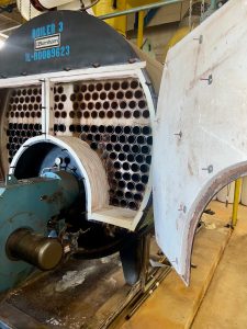 Boiler 3 undergoing lower-half retube and refractory repair, showcasing internal tubes and maintenance process in a repair facility.