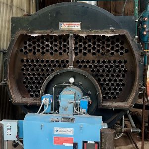 Industrial boiler with visible heat exchanger tubes and control panel, representing Kelly Boiler's repair and servicing capabilities in Monee, Illinois.