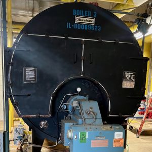 Industrial boiler with visible brand name Burnham, labeled "BOILER 3," located in Monee, Illinois, representing Kelly Boiler's repair and servicing expertise.